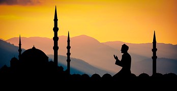 man praying in front of temple