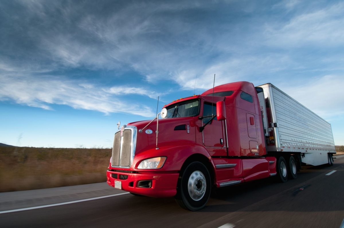 DOT red semi truck driving across the country